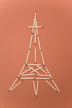 eiffel tower made of matches on red background