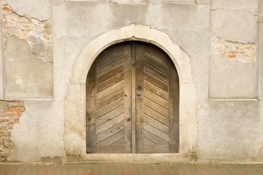 front view of wooden door and ancient wall