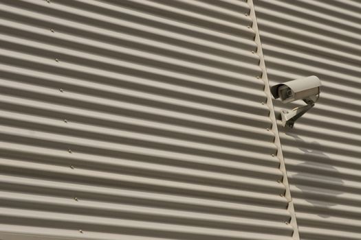 detail of surveillance camera mounted on metal facade