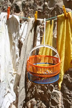 dusters out to dry on a clothes line with a basket of pegs
