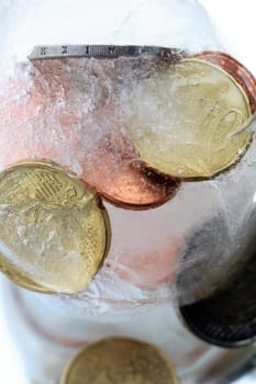Extreme closeup of coins inside ice cube