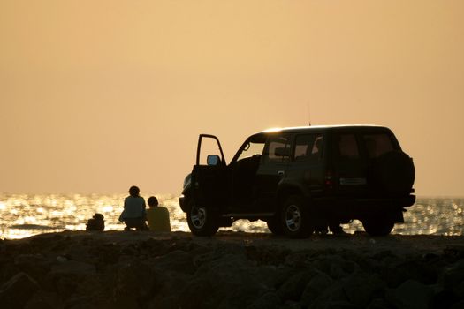 Young girl and fellow on sundown background 2