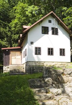 a little white house on a mountain meadow among woods