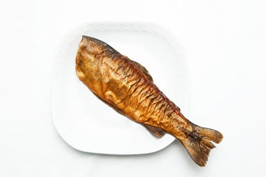 A smoked fish on the white plate