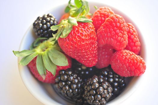 Blackberry, Raspberry and Strawberries isolated on a white background in a small white bowl.