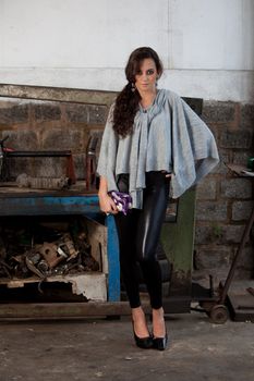 A young brazilian female model shot in a dirty auto repair shop.