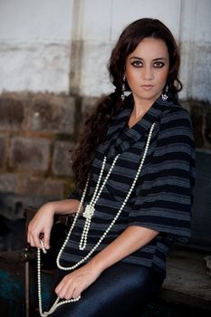 A young brazilian female model shot in a dirty auto repair shop.