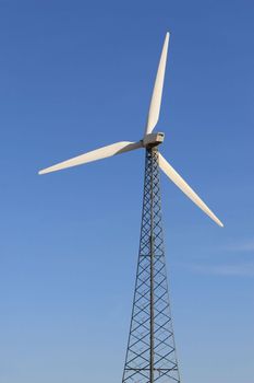 A Single Wind Turbine set against a bright blue sky