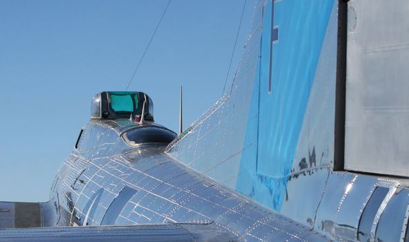 An old WWII airplane reflects the brilliant blue sky in its shiny finish