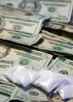 Baggies of cocaine sit onto a pile of american money. (Photographed with sugar - please don't send the police for me!)