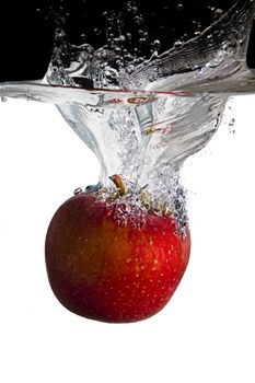 one red apple thrown in water with black and white background