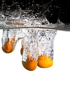 some kumquats thrown in water with black and white background