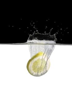 slice of an lemon thrown in water with black and white background