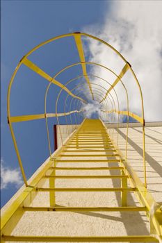 yellow stairs climbing to the sky on building