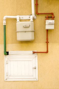 yellow wall with gas pipe and gas counter