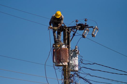 Electrician stays on the tower pole and repairs a wire of the power line. #2