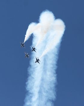 Four fighter jets flying in formation against a clear blue sky