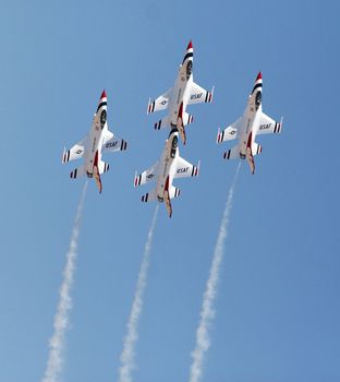 Four fighter jets flying in formation against a clear blue sky