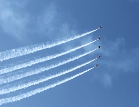 Five fighter jets flying in formation against a clear blue sky