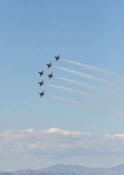 Six fighter jets flying in formation against a clear blue sky