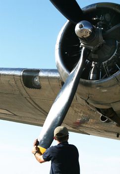 A man adjusts a large airplane propeller