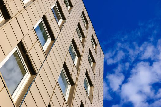 modern office building against sky with clouds