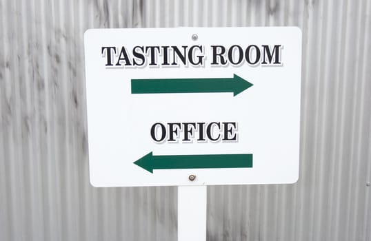 white and green winery sign with arrows