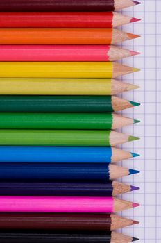 Close-up image of multicolor pencils on paper background