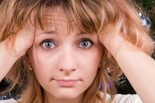 Blond young woman holding her head, headache