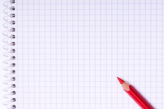 Close-up image of red pencil on paper background