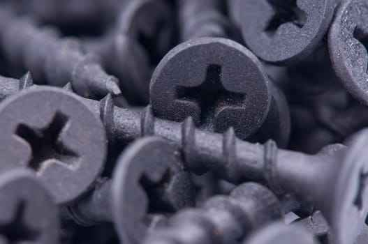 Close-up of black screws as technology background