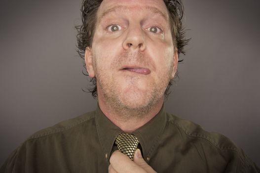 Man Concentrating Fixing Tie on a Grey Background