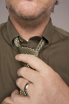 Man Fixing Tie Against Grey Background