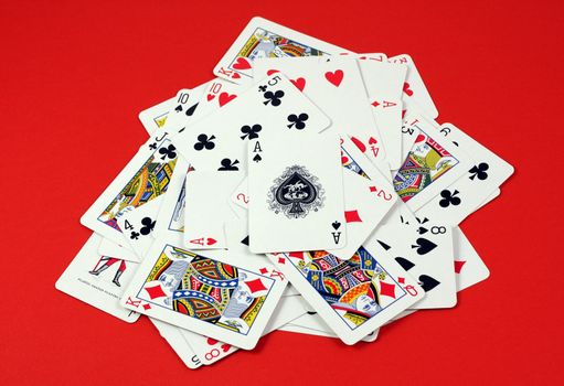 Playing cards pile on red deck