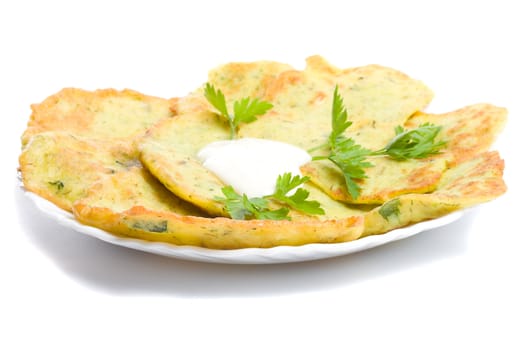 close-up pancake from marrow with parsley on plate, isolated over white background