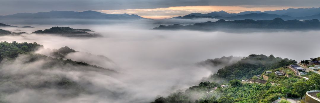 Panoramic landscape of dramatic clouds and mist in mountain.
