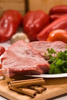 raw meat and vegetables on the wood board