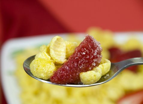 macro on a spoon full of cereals with strawberries