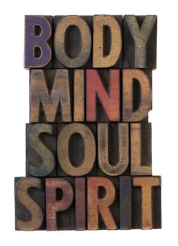body, mind, soul, spirit in vintage wooden letterpress types, stained by ink in different colors, isolated on white