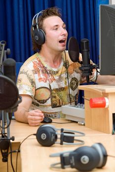 Radio DJ.  Young man with microphone and big headphone.