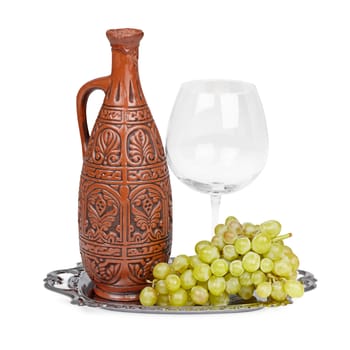 Still life of ceramic bottle, grapes and a glass on tray