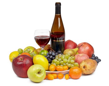A bottle of wine and a glass surrounded by fruit on white