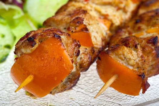 two chicken shashlik on a glass plate