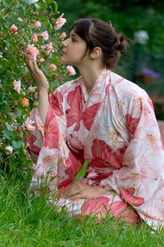 Girl in a pink yukata near rose-bush
