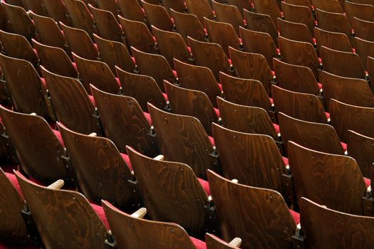 wooden chairs with red fabric, no numbers, theatre scene