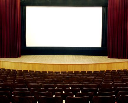 cinema, wooden seats and stage, red velvet curtain, white empty screen