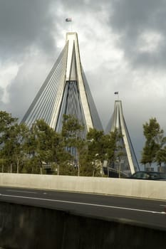 Anzac bridge in Sydney, dark grey sky, empty road in foreground