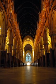 church interior, high ceiling, red lights, solitary woman standing in front of altar; St Marys Cathedral in Sydney