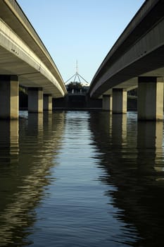 Flag pole of Australia's Parliament House between separate carriageways of Commonwealth Avenue Bridge over Lake Burley Griffin, Canberra