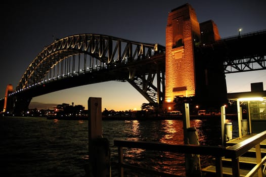 Harbour Bridge in Sydney; night scene; wooden wharf in foreground